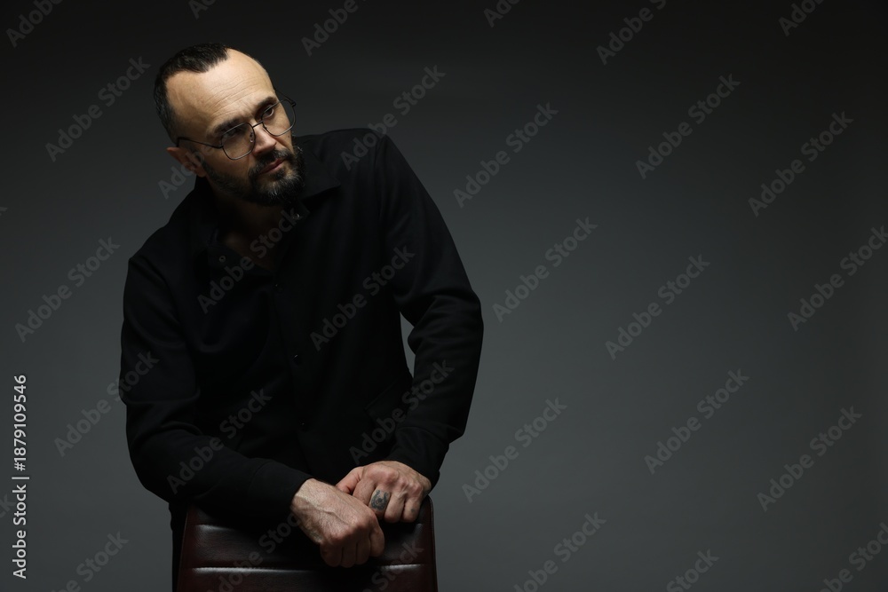 Obraz premium Fashion model. Handsome man with chair on grey background, space for text
