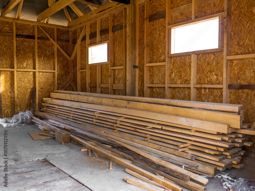 Obraz premium frame house made of timber. Lumber in the pile