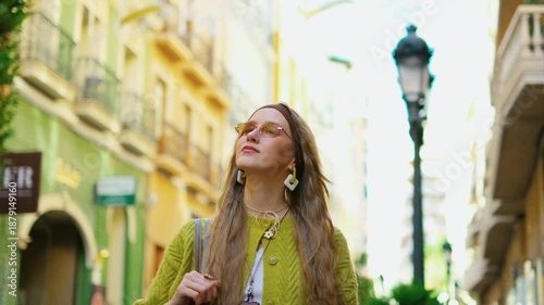 Young woman exploring vibrant urban alley in fashionable outfit