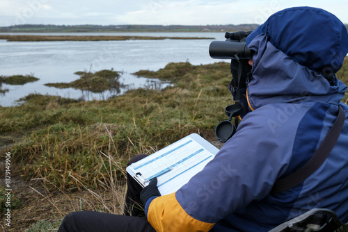 Foto Field Scientist Using Binoculars for Wildlife Observation and Ecological Restora