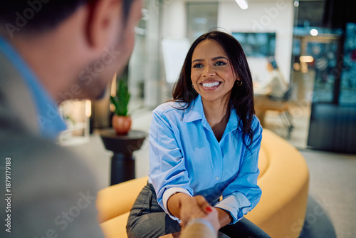 Canvastavla Smiling woman professionals shaking hands in an office, symbolizing partnership,