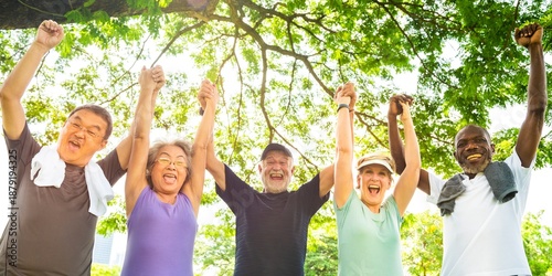 Photos Diverse group of seniors outdoors, smiling and holding hands