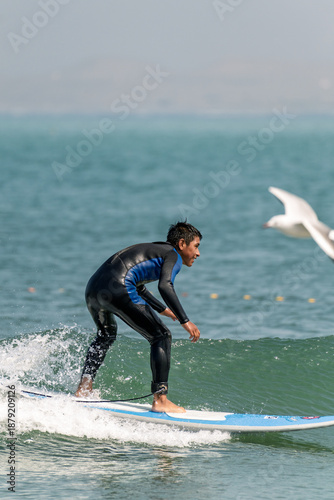 Photography Young student learning surfing on blue ocean waves