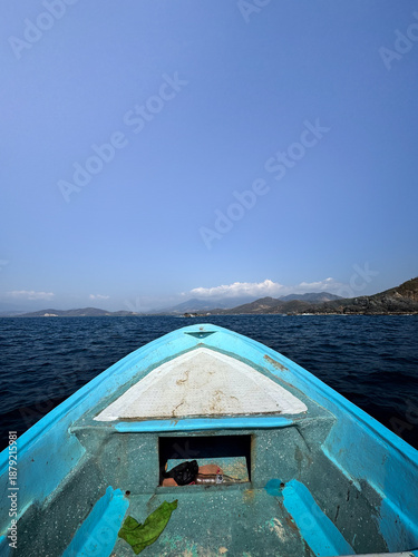 Foto Bow of a blue and white fishing boat sailing off the beach of Puerto Vicente Guerrero