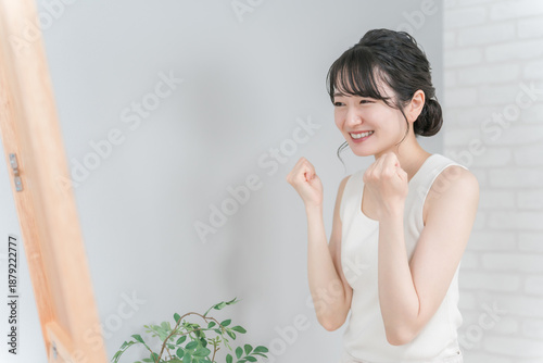Принти на полотні A smiling Asian woman pumping her fist after successfully dieting and losing wei