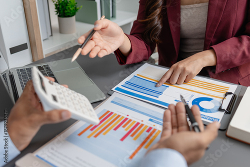 Business colleagues reviewing budget charts together in a modern office, focusing on financial insights, performance metrics, and strategic planning to support upcoming business decisions. © kamiphotos