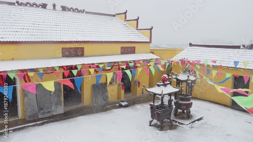 Snow-Covered Buddhist Temple with Prayer Flags and Winter Courtyard