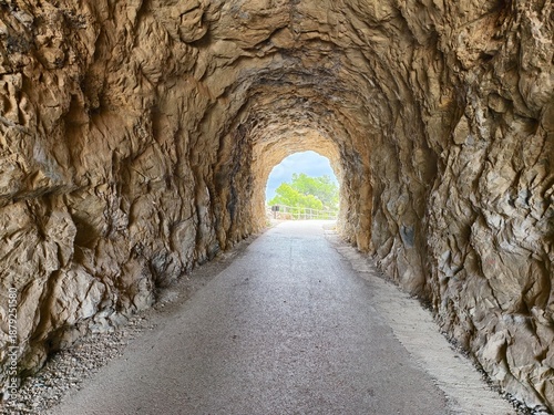 cave leads to meadow, rugged cave joins distant meadow, cave opening extends toward open meadow