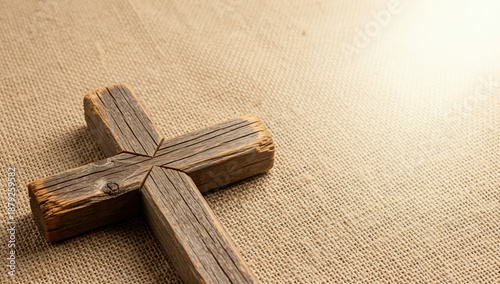 Wooden cross resting on burlap background with soft lighting  
