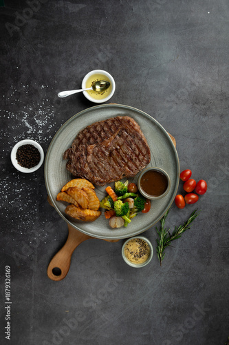 Grilled Sliced Beef Steak with Vegetables and Brown Sauce on Dark Rustic Background