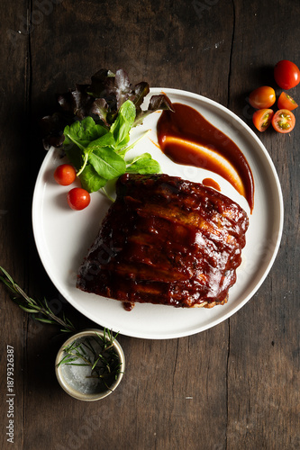 Barbecue Glazed Pork Ribs Steak with Fresh Salad and Sauce on Rustic Wooden Table