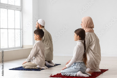 Muslim family praying in ro...