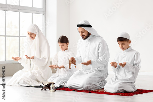 Muslim family praying in ro...