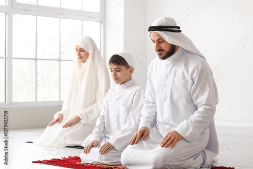 Muslim family praying in ro...