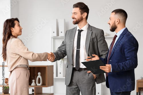 Fotografie Male court mediator and clients shaking hands in office