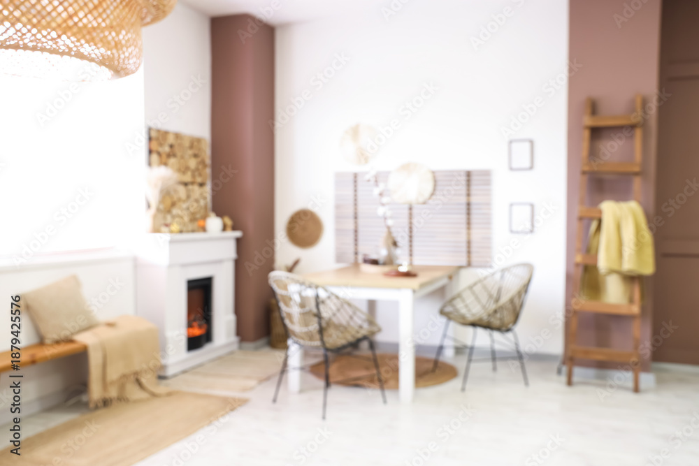 Fototapeta premium Blurred view of stylish dining room with table and fireplace