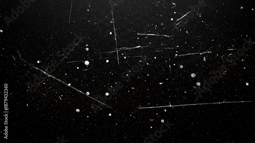 Textured black surface with numerous light scratches and specks, creating a grunge effect