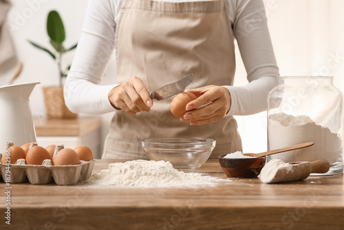 Woman breaking egg into bow...