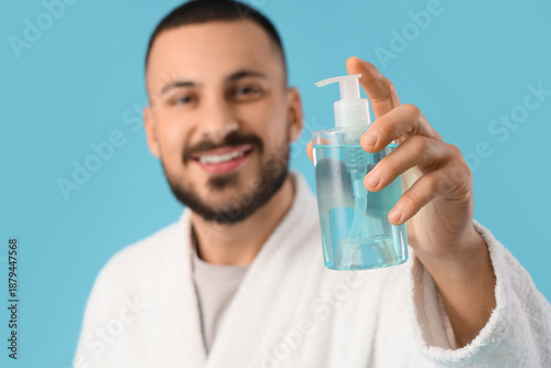 Young man in robe with bott...