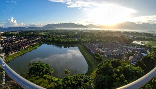 Wallpaper Mural Panoramic view of a serene lake surrounded by lush greenery and distant mountains under a bright sky. Torontodigital.ca
