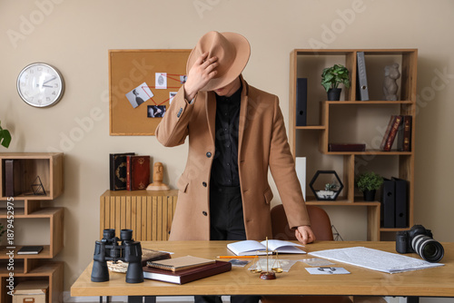Φωτογραφία Male detective near table in office