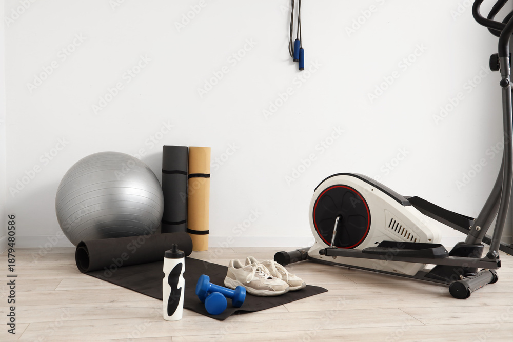 Fototapeta premium Different sports equipment near light wall in gym