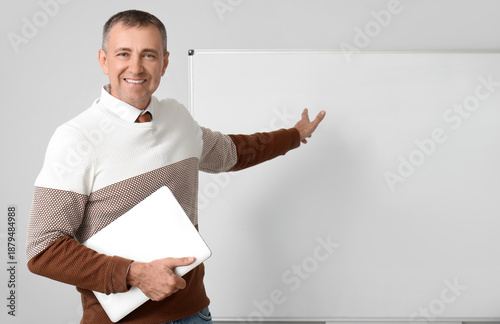 Male teacher with laptop po...
