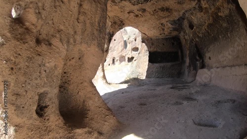 Fairy chimneys and ancient cave monasteries carved into volcanic rock landscapes of Cappadocia. Historic hoodoo formations reveal stone dwellings spires valleys seen from curious traveler view.