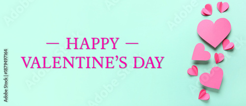 Pink paper hearts on turquoise background. Valentine's Day celebration