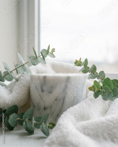 Marble podium wrapped in white towel with eucalyptus. Clean spa product display background near window