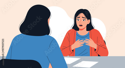 Serious conversation between two women at a desk where one appears worried and gestural while the other listens from the back.
