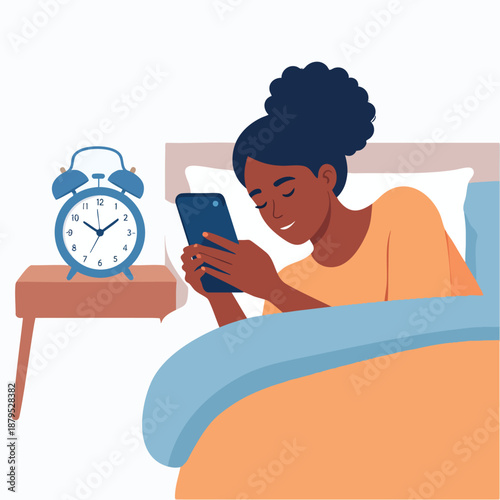 Woman lying in bed checking phone beside alarm clock on bedside table