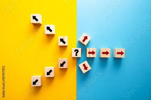 Wooden cubes with arrows showing decision uncertainty and different directions