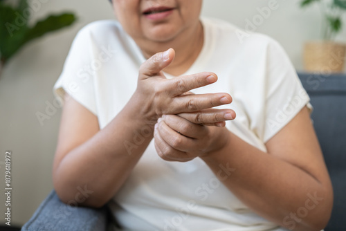 Photos Health care concept, rheumatism asian senior woman hand pain from cramp, trigger finger, wrist pain touching massaging, aged hand holding ache joint, arthritis inflammation