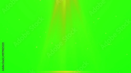 Abstract glowing golden light beam shining down onto a bright green screen background with floating dust particles for video editing