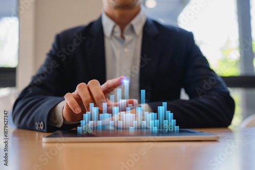 Businessman use tablet analysing graph with percentage, financial investment and tax concept, adjusting interest rates, raising interest rates, returns on investments.
