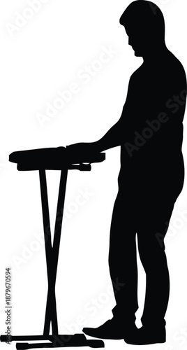 Silhouette of a male keyboard player performing on a digital piano