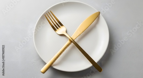 Elegant Gold Fork and Knife Crossed on White Plate for Fine Dining Concept