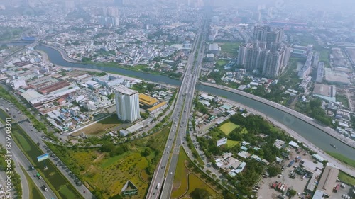 4K Aerial View Of Heavy traffic flowing through the major intersection of Vo Van Kiet Boulevard and National Route 1A in Ho Chi Minh City, Vietnam. Visible mix of cars, motorbikes, cargo trucks