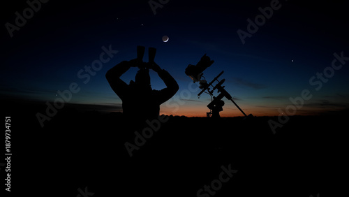 Photography Amateur astro-photographer with binoculars and camera on a tripod photographing night sky with stars, planets, Moon and other celestial objects