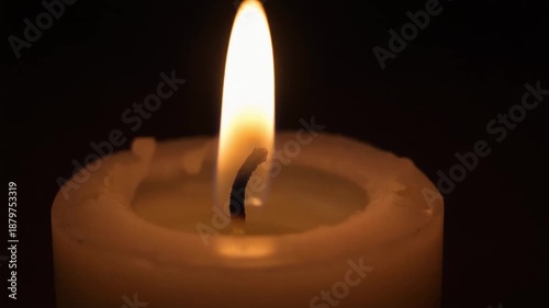 Extinguished candle in darkness symbolizing end of journey or pause