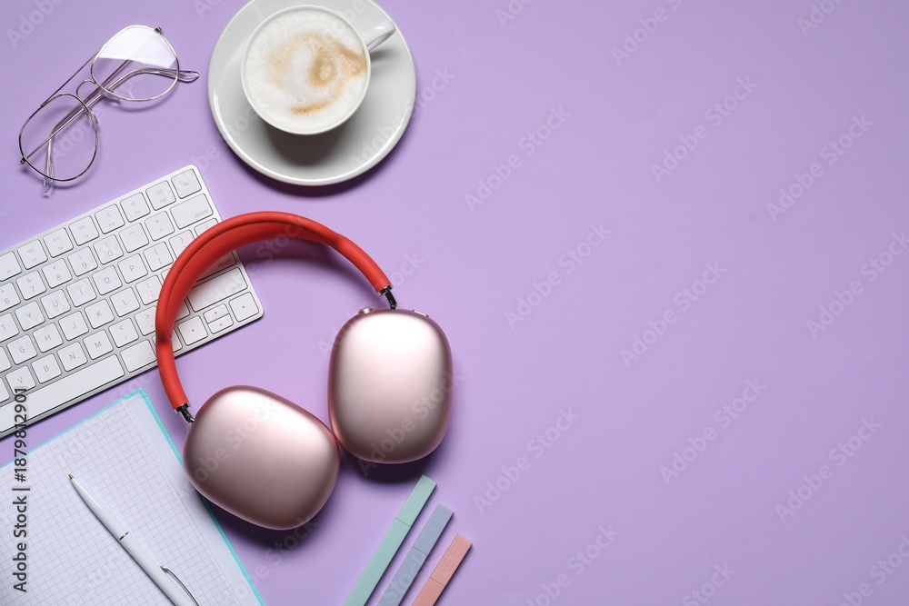 Obraz premium Headphones, smartphone, computer keyboard, coffee and stationery on violet background, flat lay. Space for text
