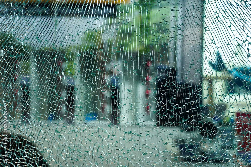 Φωτογραφία Cracked glass car with views of building in the city background