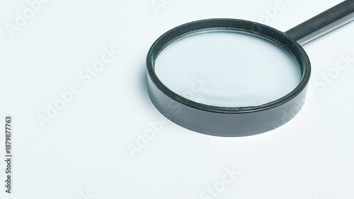 Photography Black magnifying glass on white background with large copy space for text