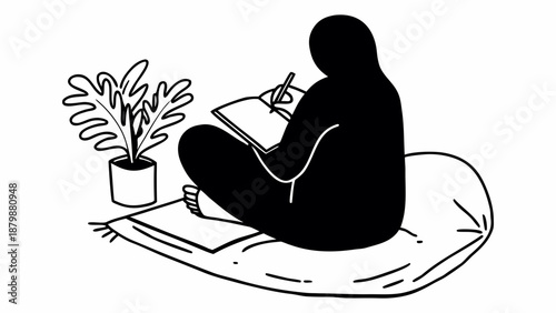 A person sitting on a cushion writes in a notebook beside a potted plant in a serene indoor setting viewed from behind