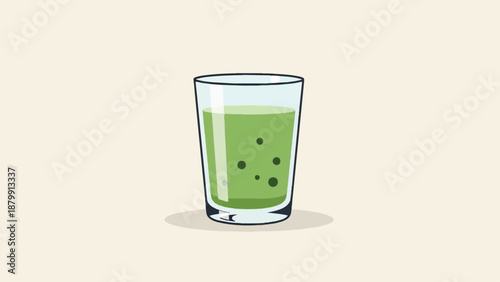 A tall glass of green liquid with dark flecks, on a light background