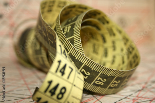 Yellow tailor's measuring tape in centimetres at working desk
