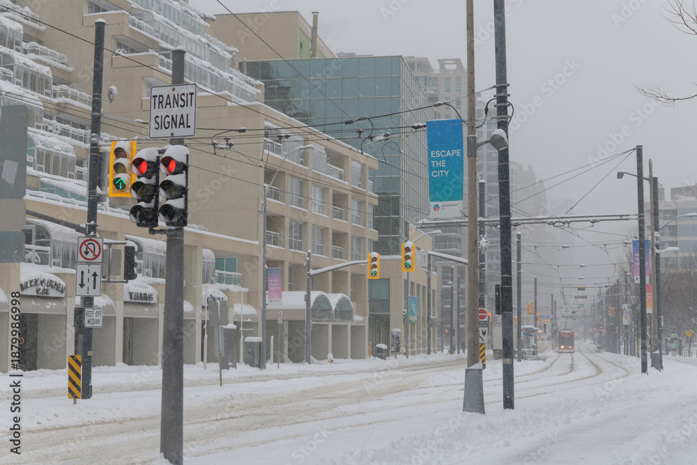 Obraz premium looking east on Queens Quay W to 509 Harbourfront and 510 Spadina streetcar routes during a snow storm on 2026-01-15 in Toronto