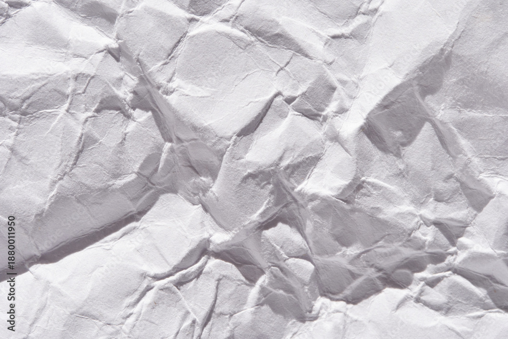 Fototapeta premium Crumpled white paper texture with detailed creases and shadows creating a rough surface.
