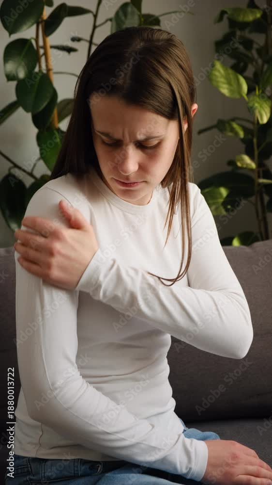 custom made wallpaper toronto digitalUnhappy sad young woman suffering from shoulder pain sitting on sofa at home. Health care and medicine. Pain body muscles stiff problem concept